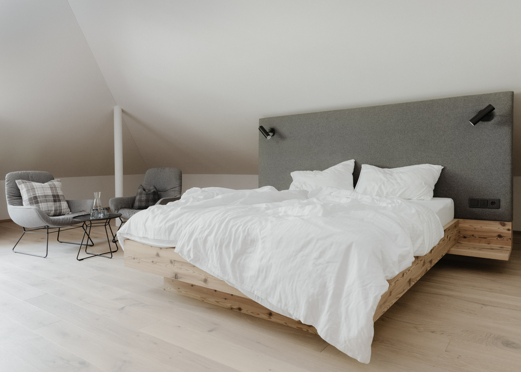 Helles Schlafzimmer mit grauem gepolstertem Kopfteil