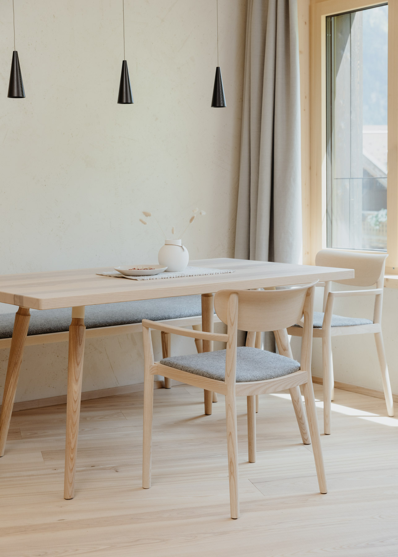 Heller Essbereich mit Holztisch und gepolsterten Stühlen