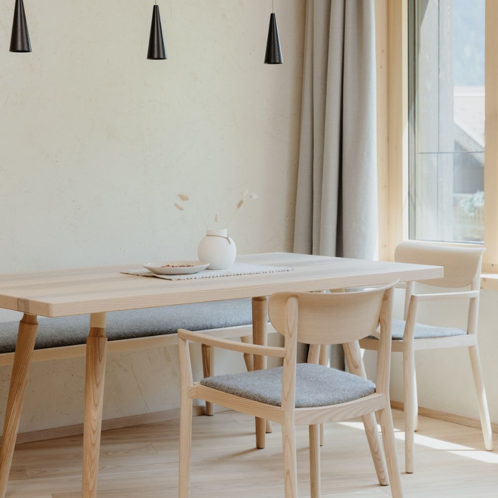 Essbereich mit Holztisch und hell gepolsterten Stühlen