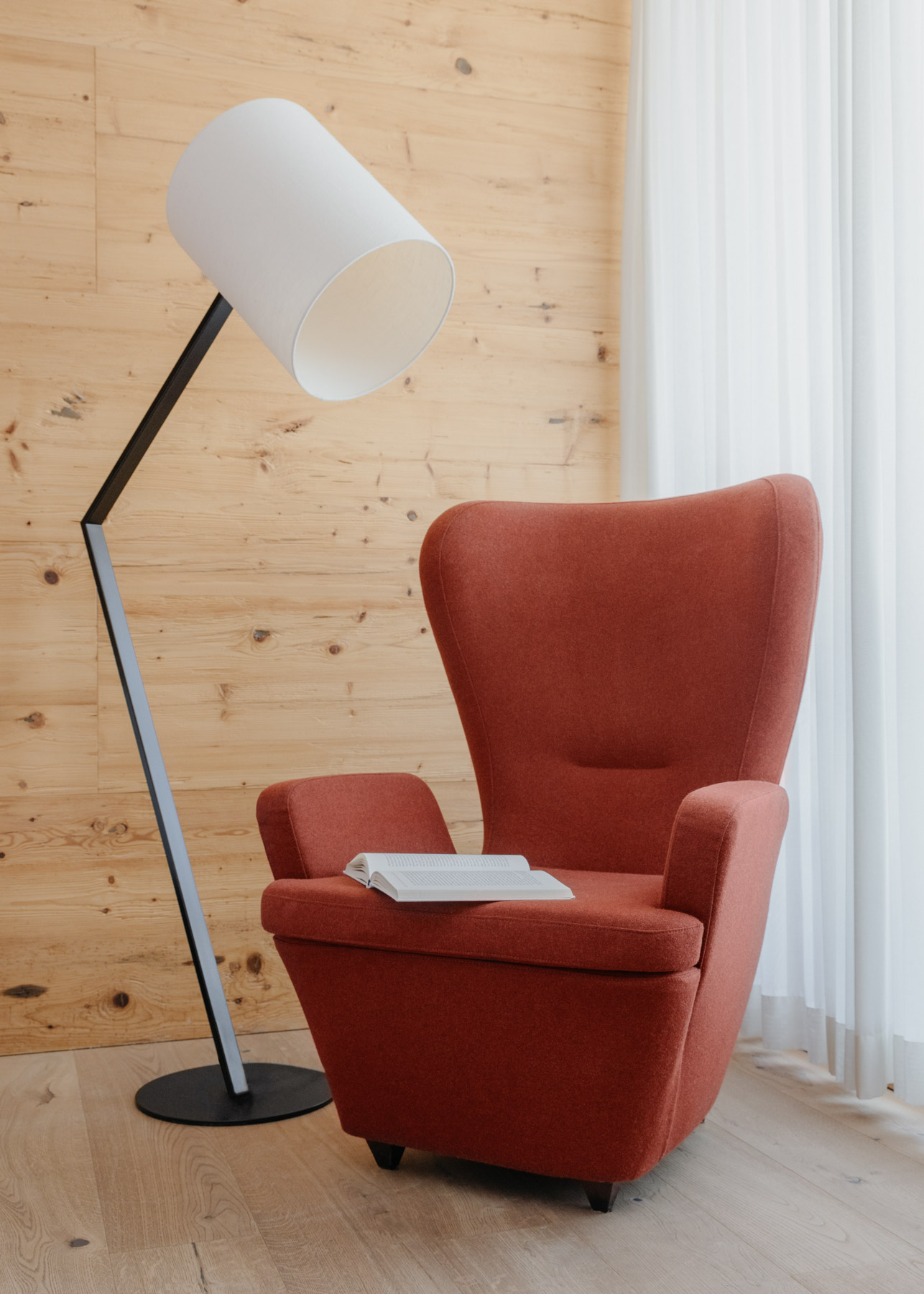 Roter Sessel mit Stehlampe in einem hellen Wohnraum